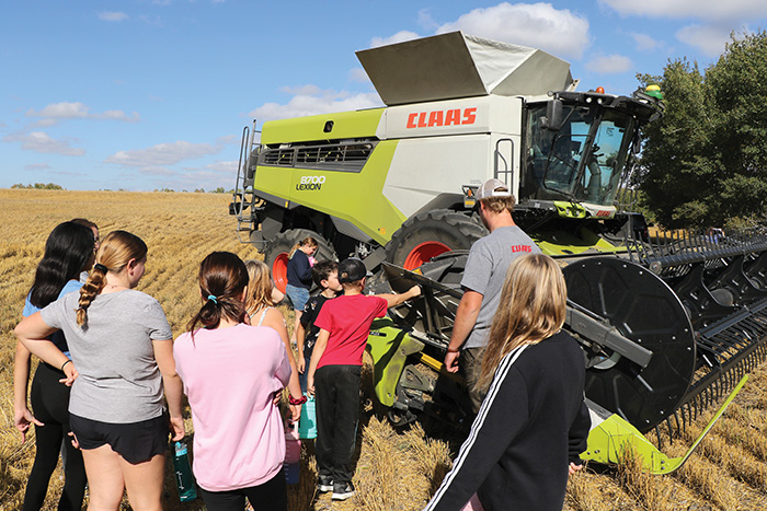 Students from Macdonald School in Stockholm were learning about a tractor and grain cart in the field, on Sept. 26. <br />